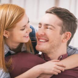 Man with hearing aids getting hug from his girlfriend or partner.