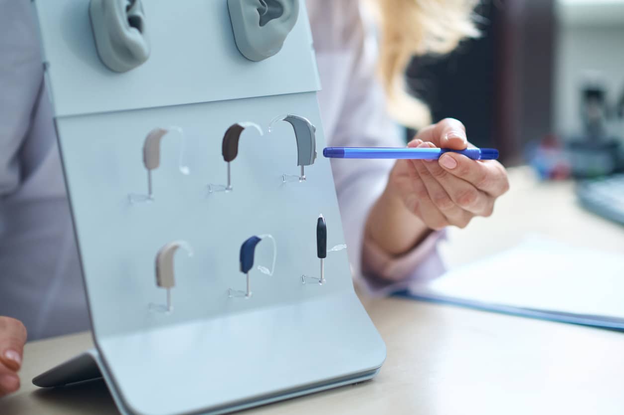 Audiologist showing hearing aid options.