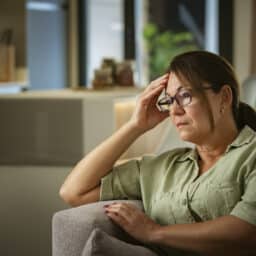 Stressed woman sitting on her couch at home