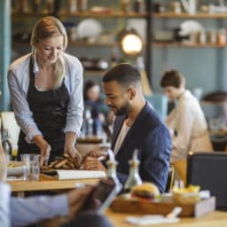 Server bringing food to a table of two
