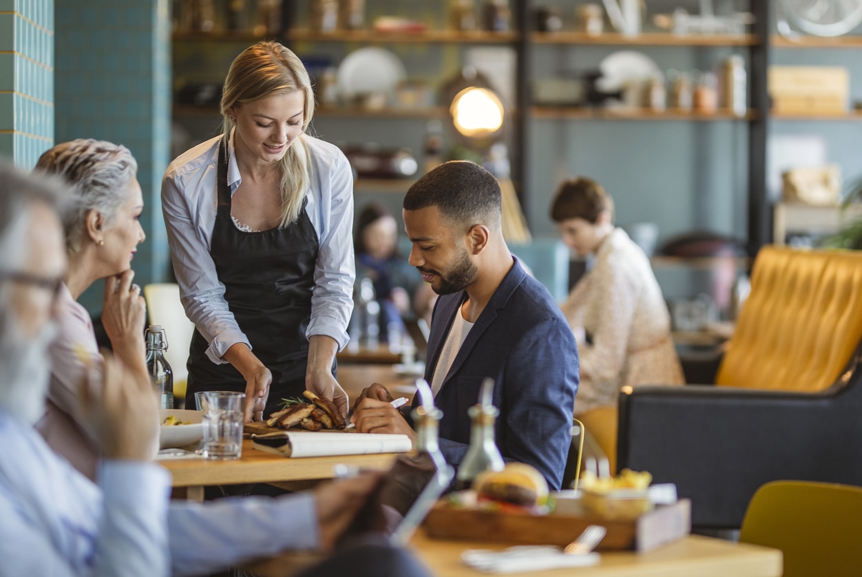 Server bringing food to a table of two.